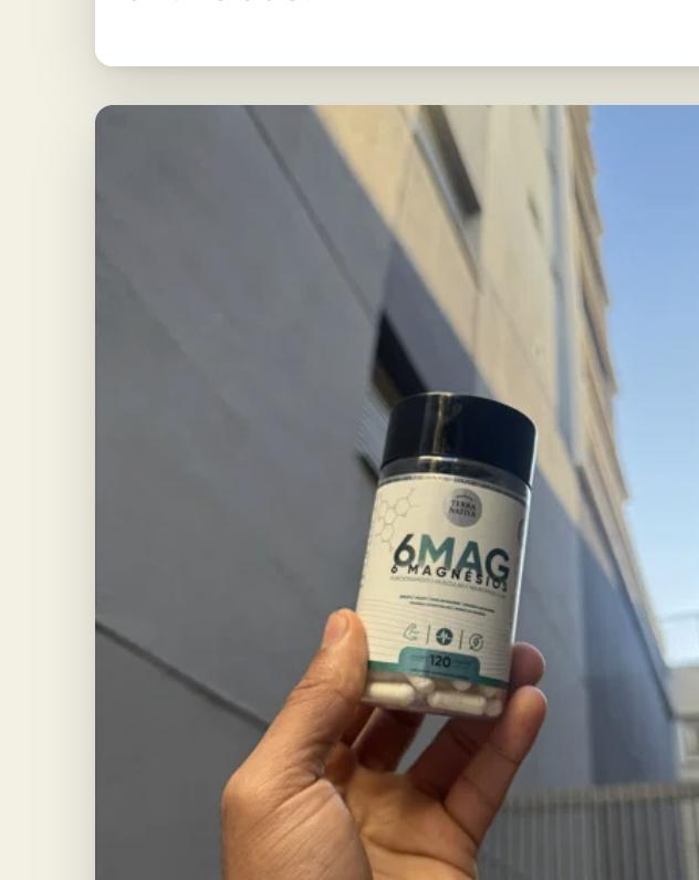 Cliente segurando o pote de 6 Magnésios Quelato ao lado de um prédio