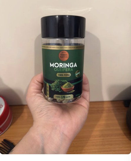 Cliente segurando o pote de Moringa 100% Pura