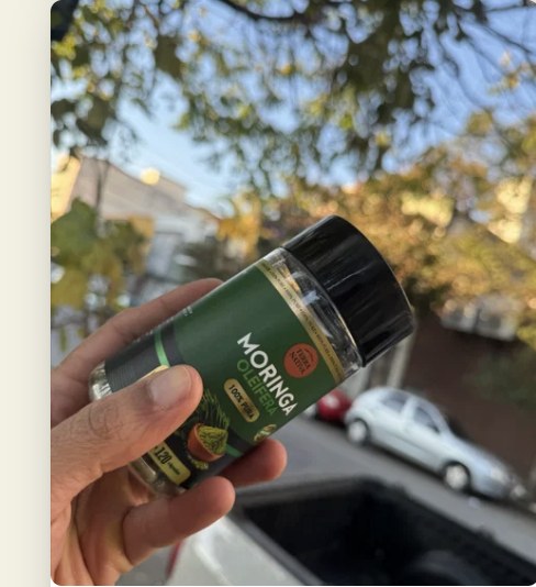 Cliente segurando o pote de Moringa 100% Pura