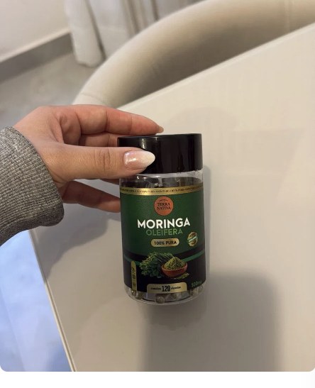 Cliente segurando o pote de Moringa 100% Pura